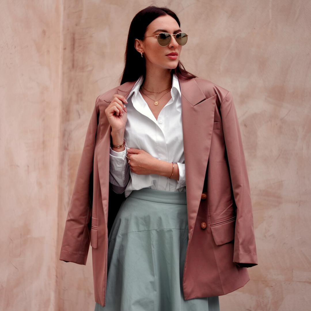 Vrouw in roze blazer met lichtblauwe rok, casual look